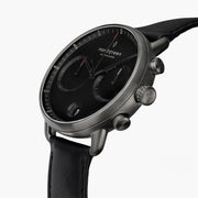 Angled view of the black dial, subdials and gunmetal pushers.