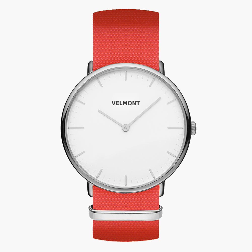 Minimalist watch with a white dial and silver-tone case on a bright red woven strap.