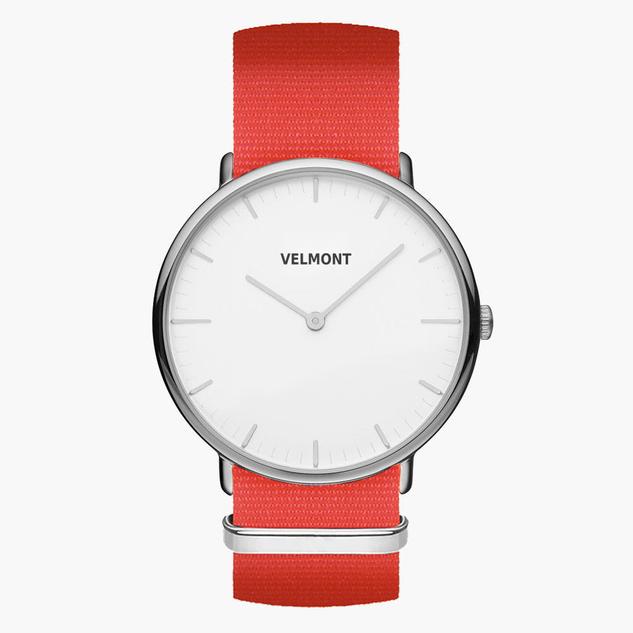 Minimalist watch with a white dial and silver-tone case on a bright red woven strap.
