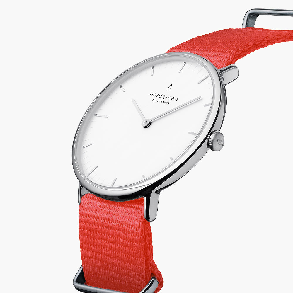 Three-quarter view of the thin silver-tone case on a red fabric strap.