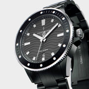 Angled view of the black case, knurled crown and bracelet links.