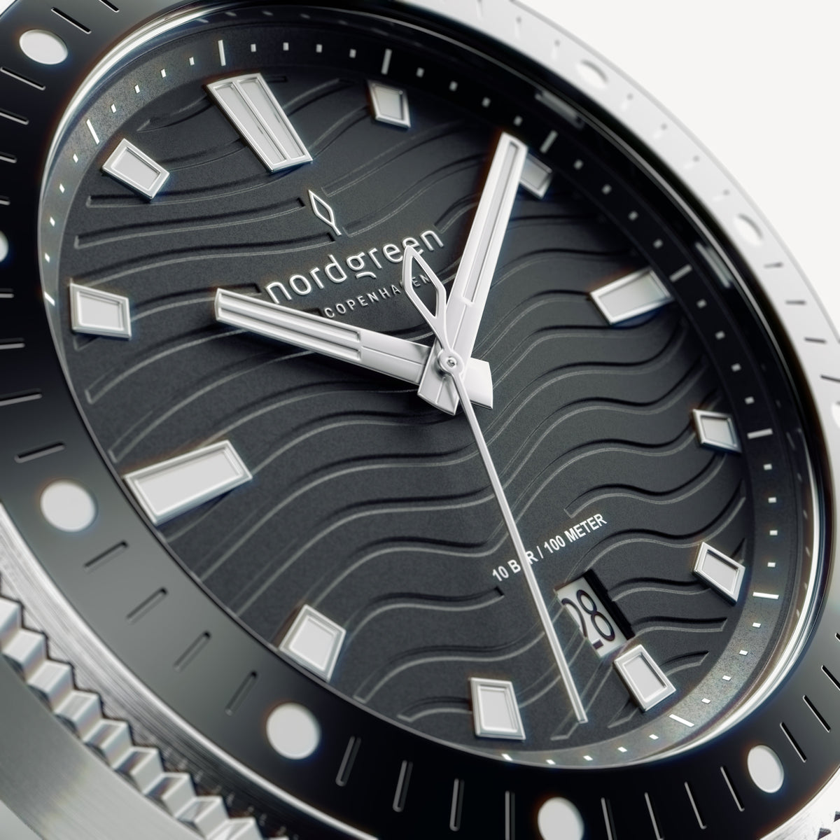 Close-up of the wave-textured black dial with bold white-filled hands.