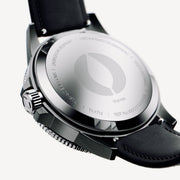 Angled case back with an engraved emblem and the black strap attached.