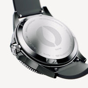 Case back of the dark watch with a black strap attached.