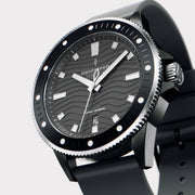 Angled view of the dark case, dotted bezel and silver-tone crown.