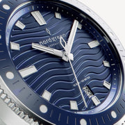 Close-up of the wave-textured blue dial, filled hands and the date window.