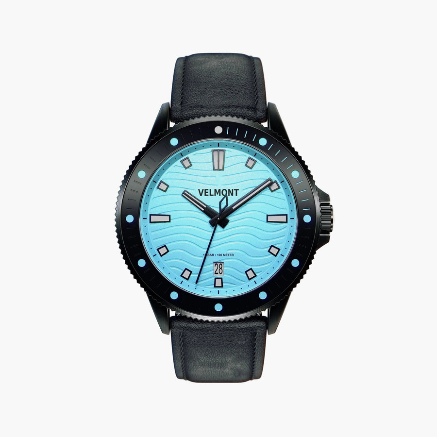 Black diver-style watch with a light turquoise wave dial on a matte black strap.