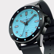 Angled view of the black case and dotted bezel around the turquoise dial.