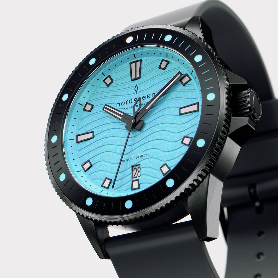 Angled view of the black case and dotted bezel around the turquoise dial.