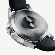 Brushed silver-tone case back with an engraved emblem, black strap attached.