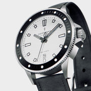 Angled view of the silver-tone case, knurled crown and dotted black bezel.