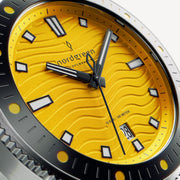 Close-up of the yellow wave-textured dial with white-filled indices and date window.