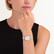 Oval two-tone watch worn at the chin