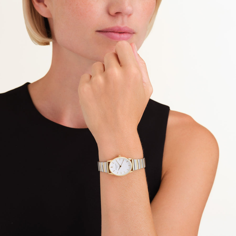 Oval two-tone watch worn at the chin