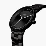 Angled view of the black case, fluted crown and white hands.