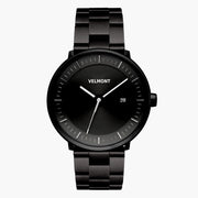 All-black watch with a sunburst dial and date window on a black link bracelet.