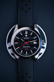 Black dial watch on a black strap against a blue background