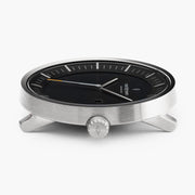 Profile of the watch head in silver-tone, crown facing the camera.