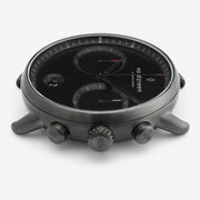 Side profile showing the crown between two pushers on the dark case.