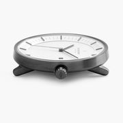 Low side view of the slim gunmetal case and its knurled crown.