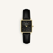 Gold-tone square watch with black dial and black strap, front view