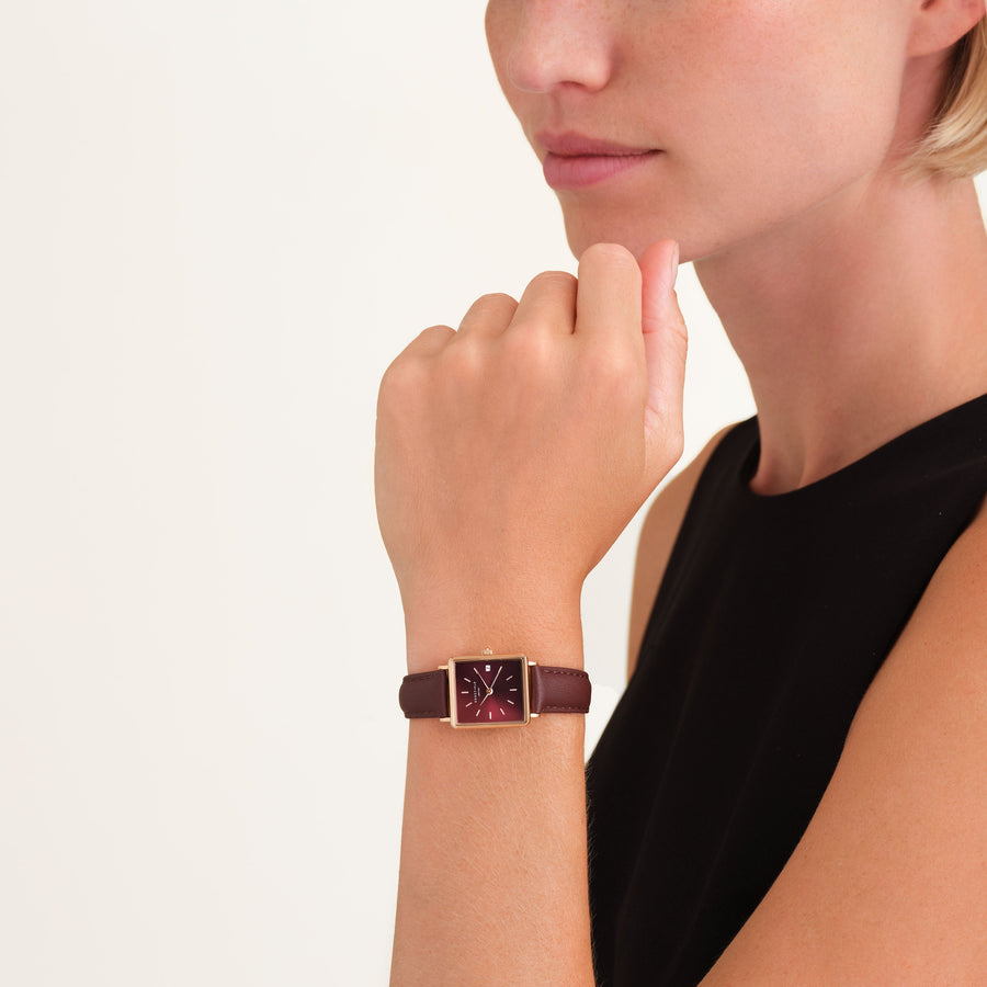 Burgundy-dial watch worn at the chin