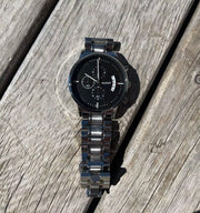 Black bracelet watch on weathered wood