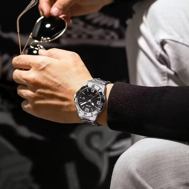 Steel watch on a wrist with sunglasses in hand