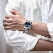 Blue dial watch on a white sleeve