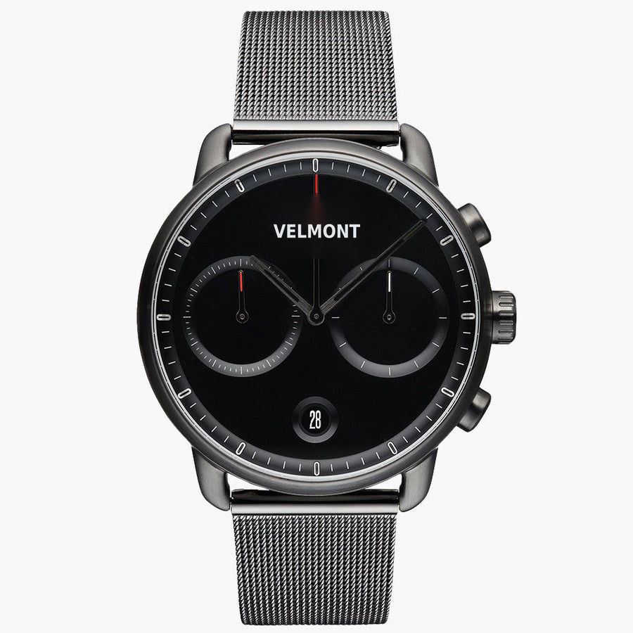 Chronograph-style watch with a black dial and gunmetal case on a matching mesh strap, front view.