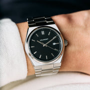 The watch worn on a wrist, paired with a white knit sleeve.