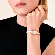 Rose gold-tone bangle watch worn with a black top