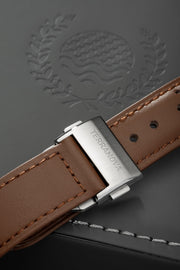 Brown strap and buckle on an embossed surface