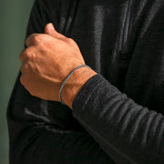 Wheat chain bracelet worn with a dark sweater