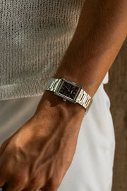 Wrist in a knit sweater wearing the rectangular watch
