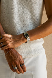 Arms crossed over a knit top, watch on the wrist