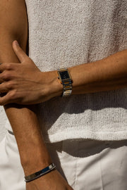 Arms crossed over a knit top, watch on the wrist