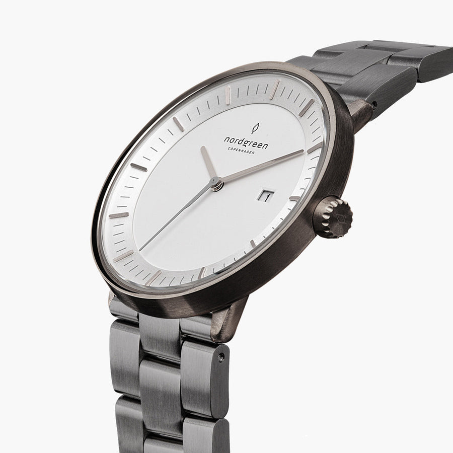 Three-quarter view of the gunmetal case, fluted crown and white dial.