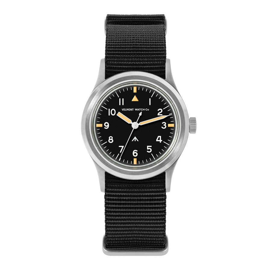 Black-dial retro military watch with cream hands on a black nylon strap