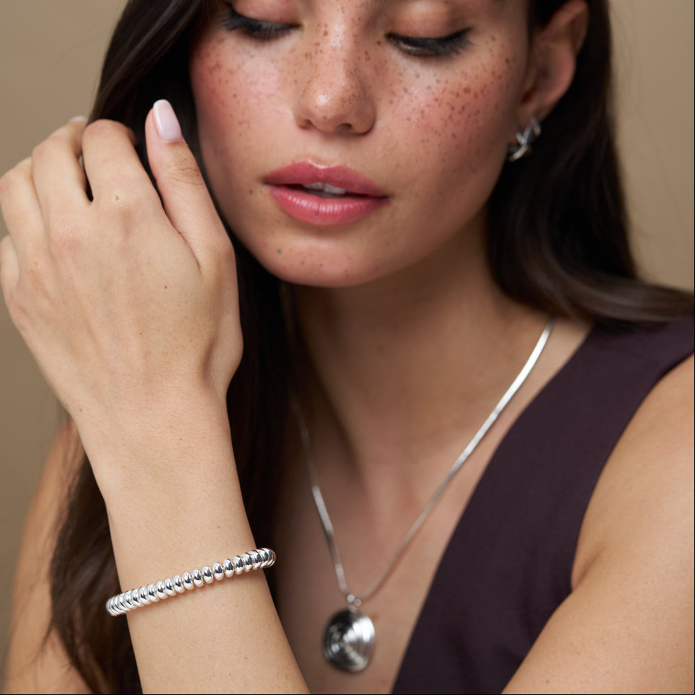 Nugget bead bracelet worn with a pendant necklace