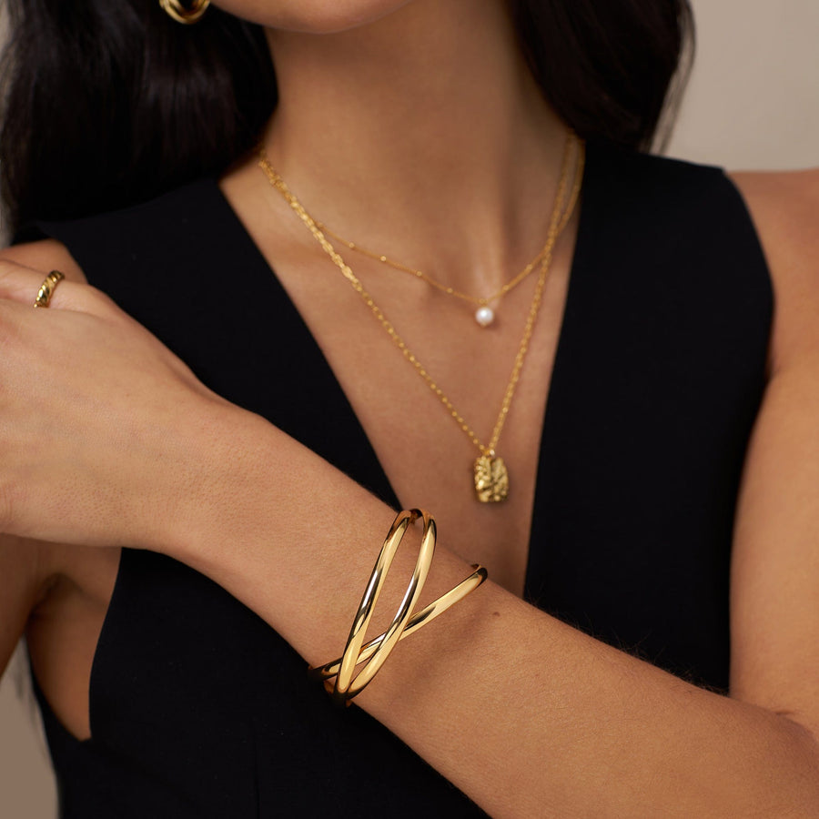 Interlocking bangles worn with layered necklaces