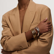 Interlocking bangles worn with a camel blazer