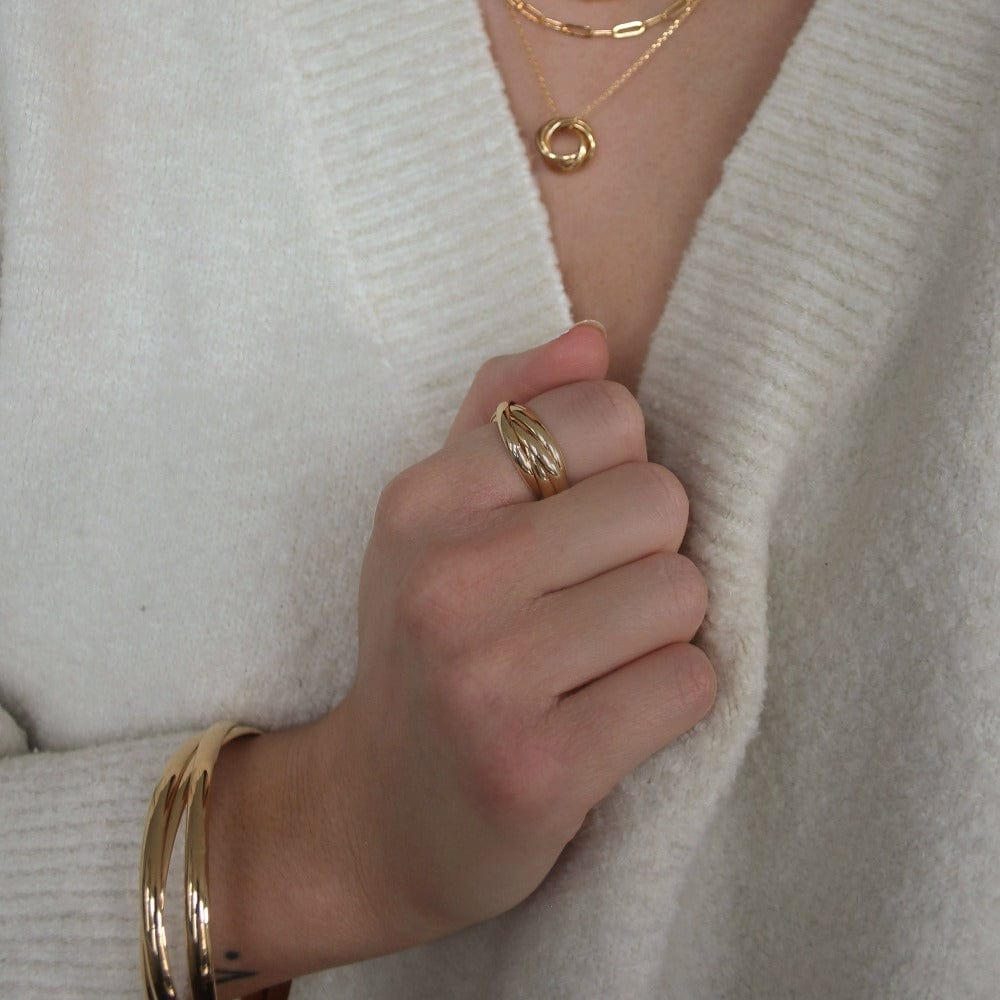 Interlocking bangles worn with a cream sweater