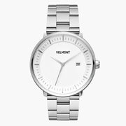 Silver-tone watch with a white dial and date window on a three-row bracelet.