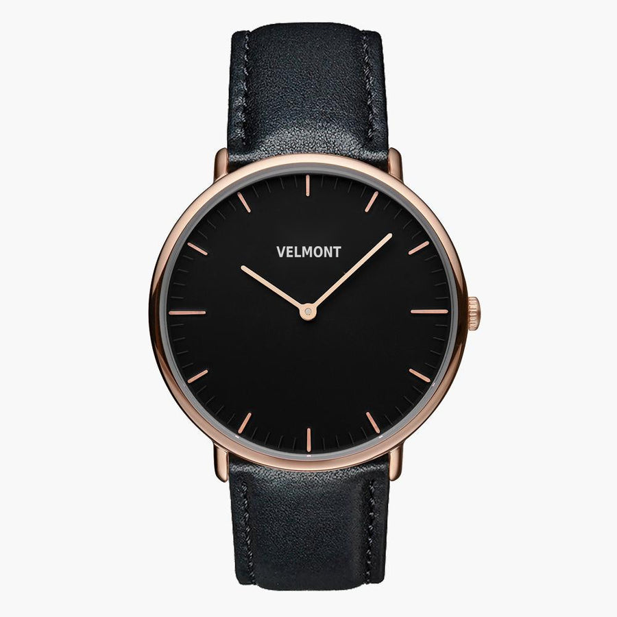 Watch with a black dial and rose gold-tone case on a black strap, shown from the front.