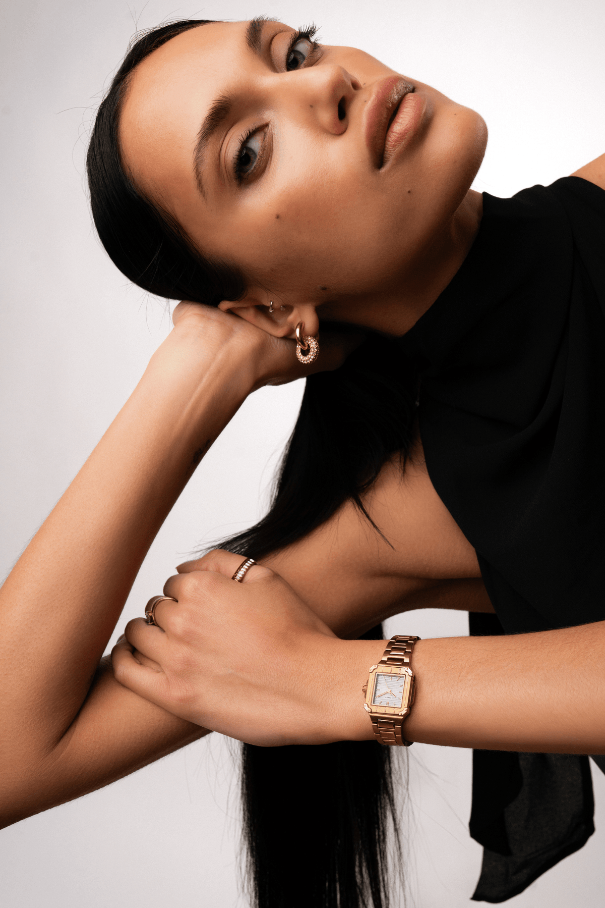 Woman leaning on her arm wearing the small square watch