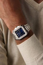 Square watch on a wrist in a cream sweater