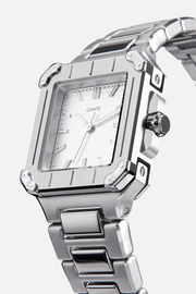 Angled view of the square case with screw details at the corners and silver dial
