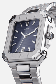Angled view of the square case with screw details at the corners and navy blue dial