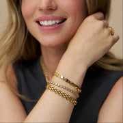 Watch-style link bracelet stacked with other bracelets